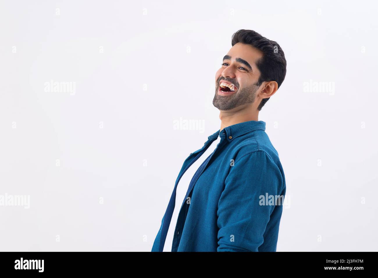 Porträt eines glücklichen jungen Mannes, der woanders hinschaut und lacht Stockfoto