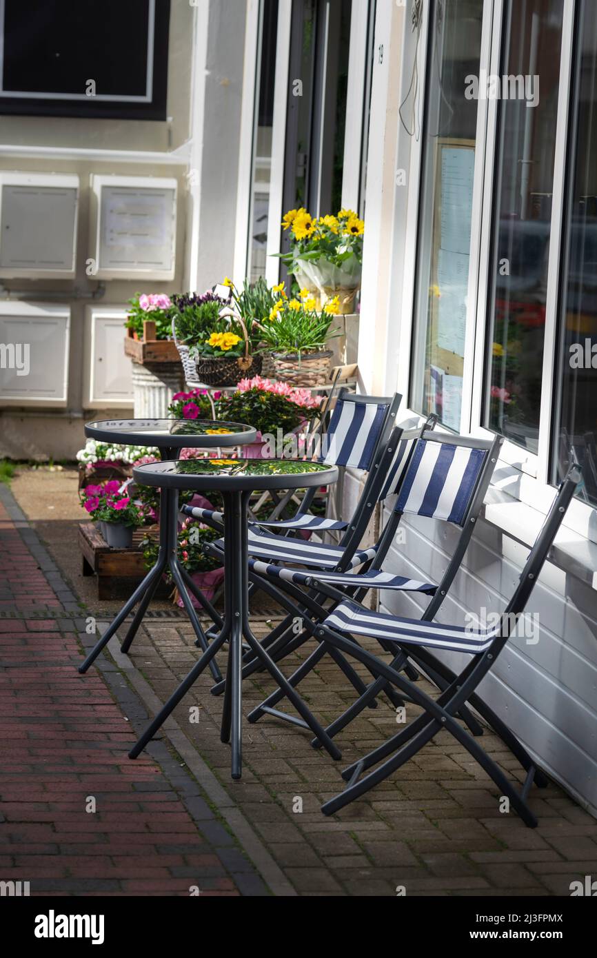 Sitzplätze im Freien in einem Café an der Straße mit Blumen Stockfoto