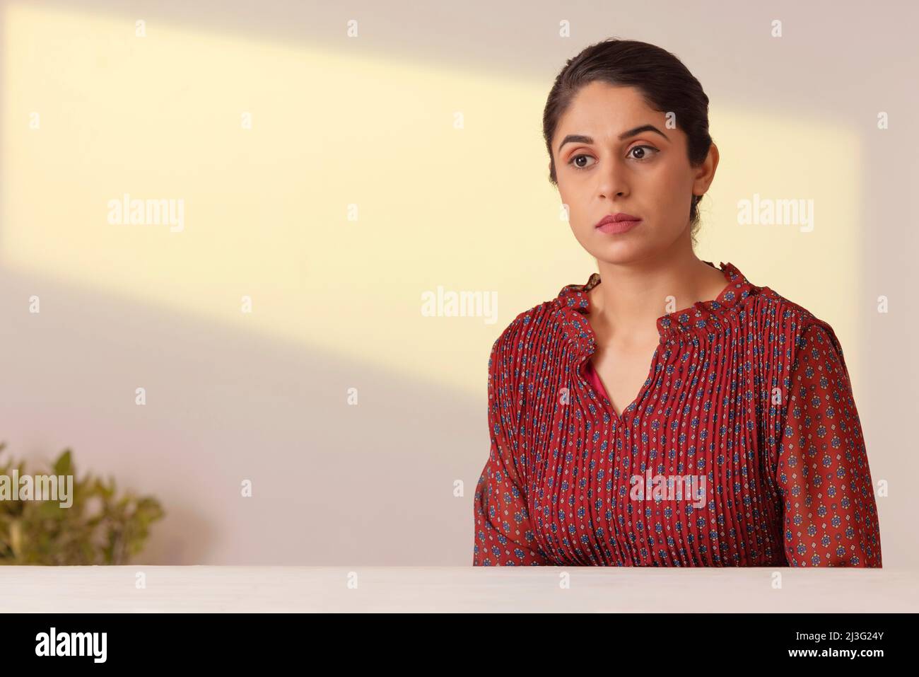 Porträt einer jungen Frau, die woanders hinschaut und denkt Stockfoto