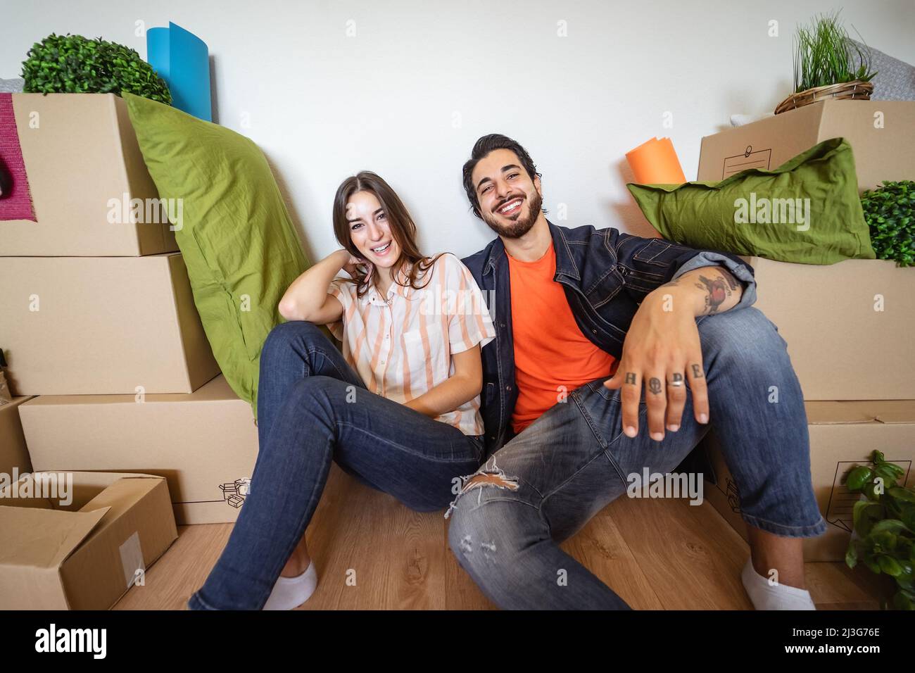 Glückliches junges Paar, das zum ersten Mal in ein neues Zuhause zieht - Ändern Sie den Tag der Wohnung und das Lifestyle-Konzept für junge Menschen Stockfoto