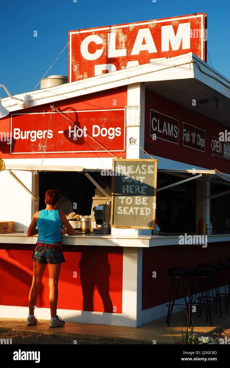 Am Sommertag wartet eine Kellnerin am Schalter einer Muschel-Hütte in East Hampton, Long Island, bereit, die Kunden zu bedienen Stockfoto