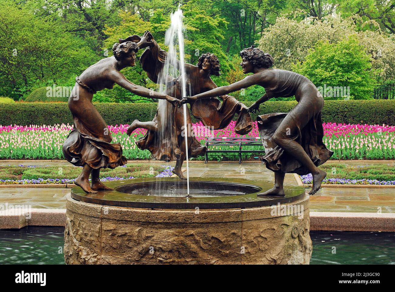 Die Skulptur von drei tanzenden Nymphen, die einen Wasserbrunnen umkreisen, zeigt die Conservatory Gardens im New Yorker Central Park im Frühjahr Stockfoto