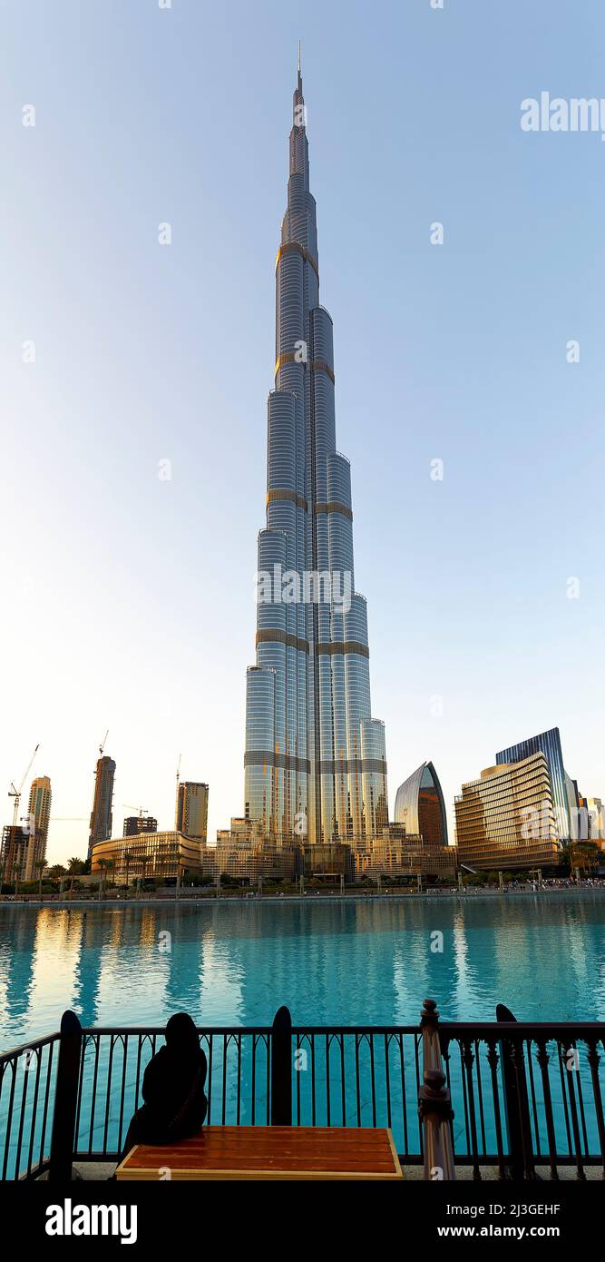 Dubai. VAE. Burj Khalifa. Eine verschleierte Frau auf einer Bank Stockfoto