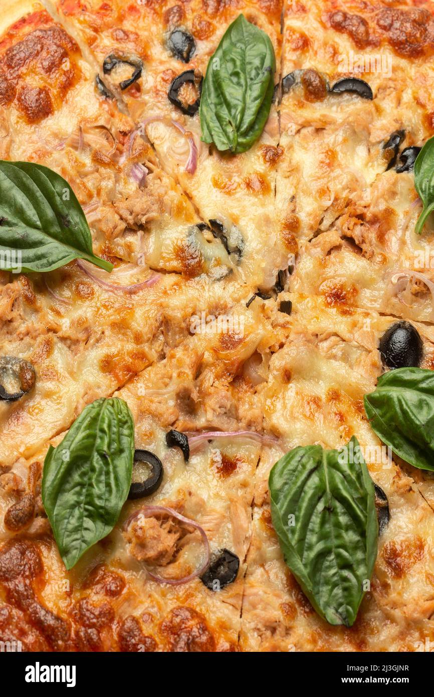 Nahaufnahme Detail von gemischtem Bio-Gemüse vegetarische Pizza mit frischem Basilikum Stockfoto