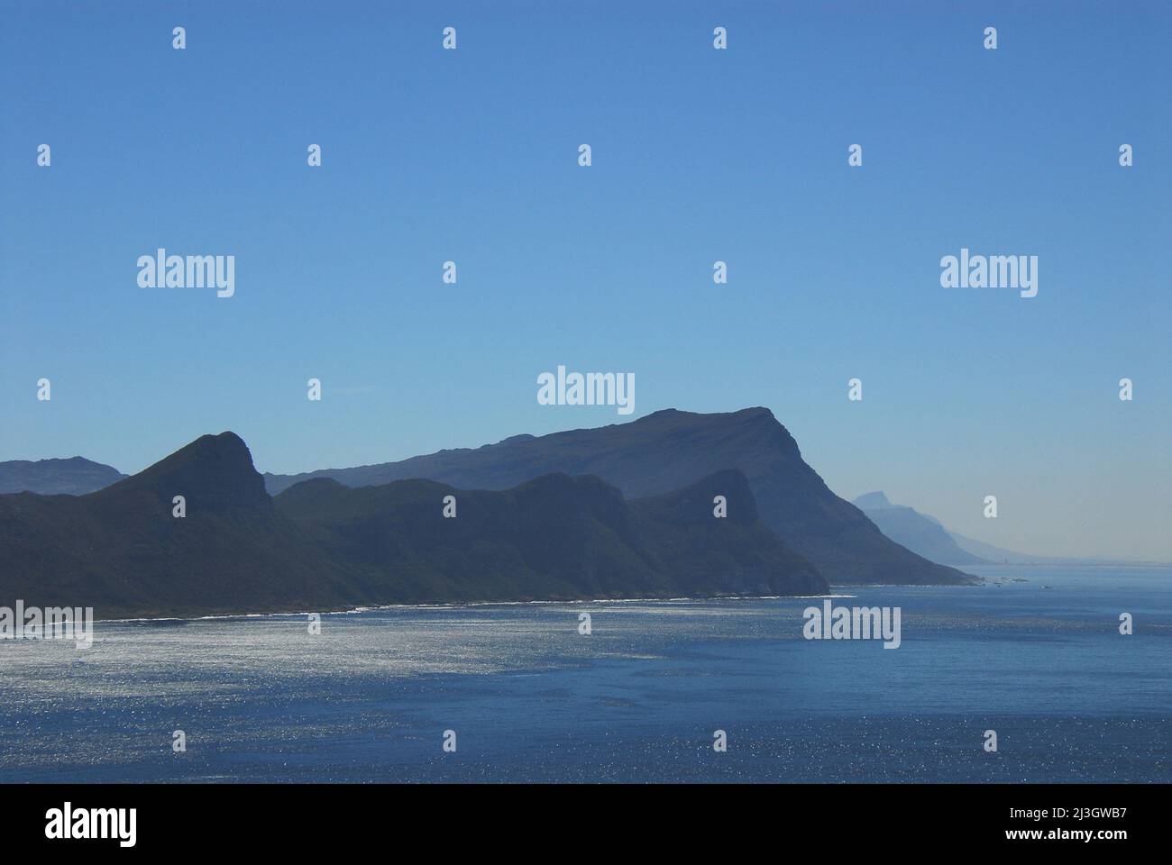 Ein nebliger Tag schafft ein wunderschönes Panorama von abstrakten Bergformen entlang der Küste der Kap-Halbinsel in Südafrika. Stockfoto