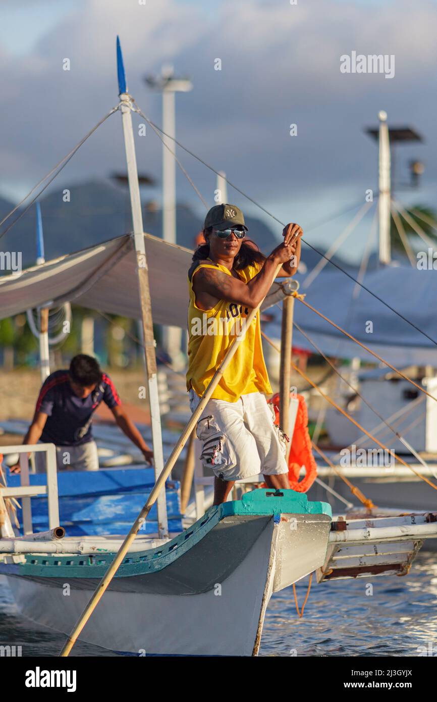 Philippinen, Palawan, Calamianes Archipel, Coron Stadt, ein Mann führt ein Kanu auf den Markt Stockfoto
