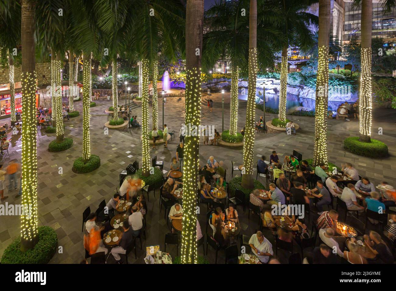 Philippinen, Metro Manila, Makati District, Greenbelt Mall, Terrassenbar und Kokospalmen mit Lametta-Lichtern Stockfoto