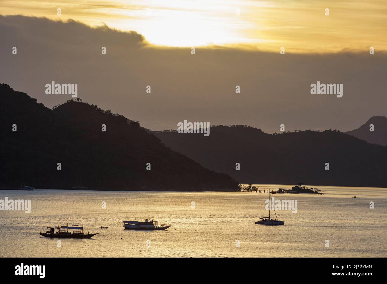 Philippinen, Palawan, Calamians-Archipel, Coron Town, Sonnenuntergang über dem Meer und Kanus gegen das Licht Stockfoto
