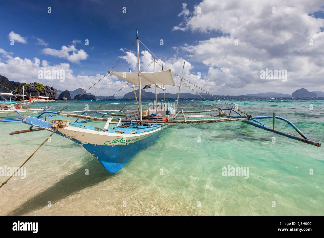 Philippinen, Palawan, El Nido, Bacuit-Archipel, Shimizu Island, outrigger Kanu auf dem türkisfarbenen und transparenten Wasser des weißen Sandstrands Stockfoto