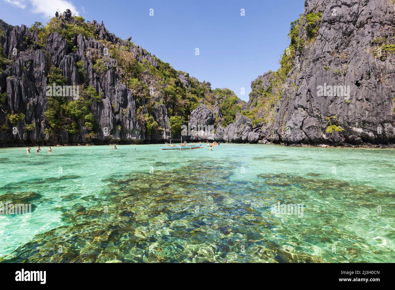 Philippinen, Palawan, El Nido, Bacuit-Archipel, Touristen, die vor der Insel Miniloc in transparentem Wasser baden Stockfoto