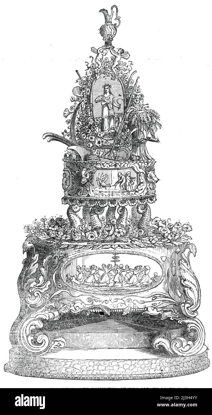 Colossal Prize Bride-Cake, ausgestellt auf der Albany State Fair, 1850. Hochzeitstorte von Benjamin Briare, '...auf verzierten Buchsenpodesten erhöht...mit einem Brautkranz aus Blumen, das ganze wird von einem glänzend geschnitzten Altar überragt, der von acht Delfinen unterstützt wird...auf dem Altar verstreut sind landwirtschaftliche Geräte, Obst und Gemüse aller Arten, sogar der bescheidenen Kartoffel. In der Mitte steht ein Medaillon, dessen Seiten schön reliefmodelliert sind. Auf der einen Seite ist Ceres, die Göttin der Landwirtschaft...Dieses Medaillon ist mit einem herrlichen Blumenkranz und Res umschlungen Stockfoto