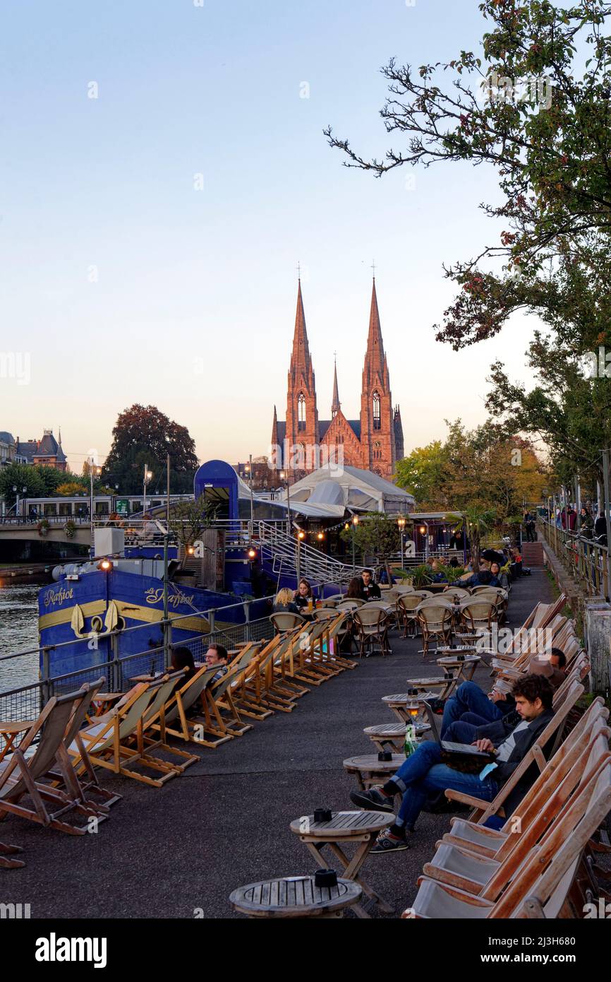 Frankreich, Bas-Rhin, Straßburg, Altstadt, die von der UNESCO zum Weltkulturerbe erklärt wurde, Cafés Boote auf dem Quai des Batelers am Ufer der Ill und Saint-Paul Kirche im Hintergrund Frankreich, Bas-Rhin (67), Straßburg, vieille ville classée au Patrimoine Mondial de l'UNESCO, Bistrots péniches le long du quai des Pêcheurs au Bord de l'ill avec église Saint-Paul en arrière Plan Stockfoto