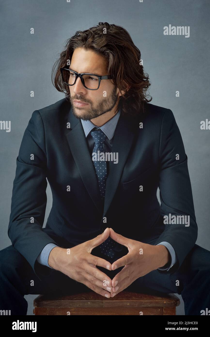 Ein Gentleman zu sein, zeigt sich in deinem Aussehen. Studioaufnahme eines gut gekleideten Geschäftsmanns vor grauem Hintergrund. Stockfoto