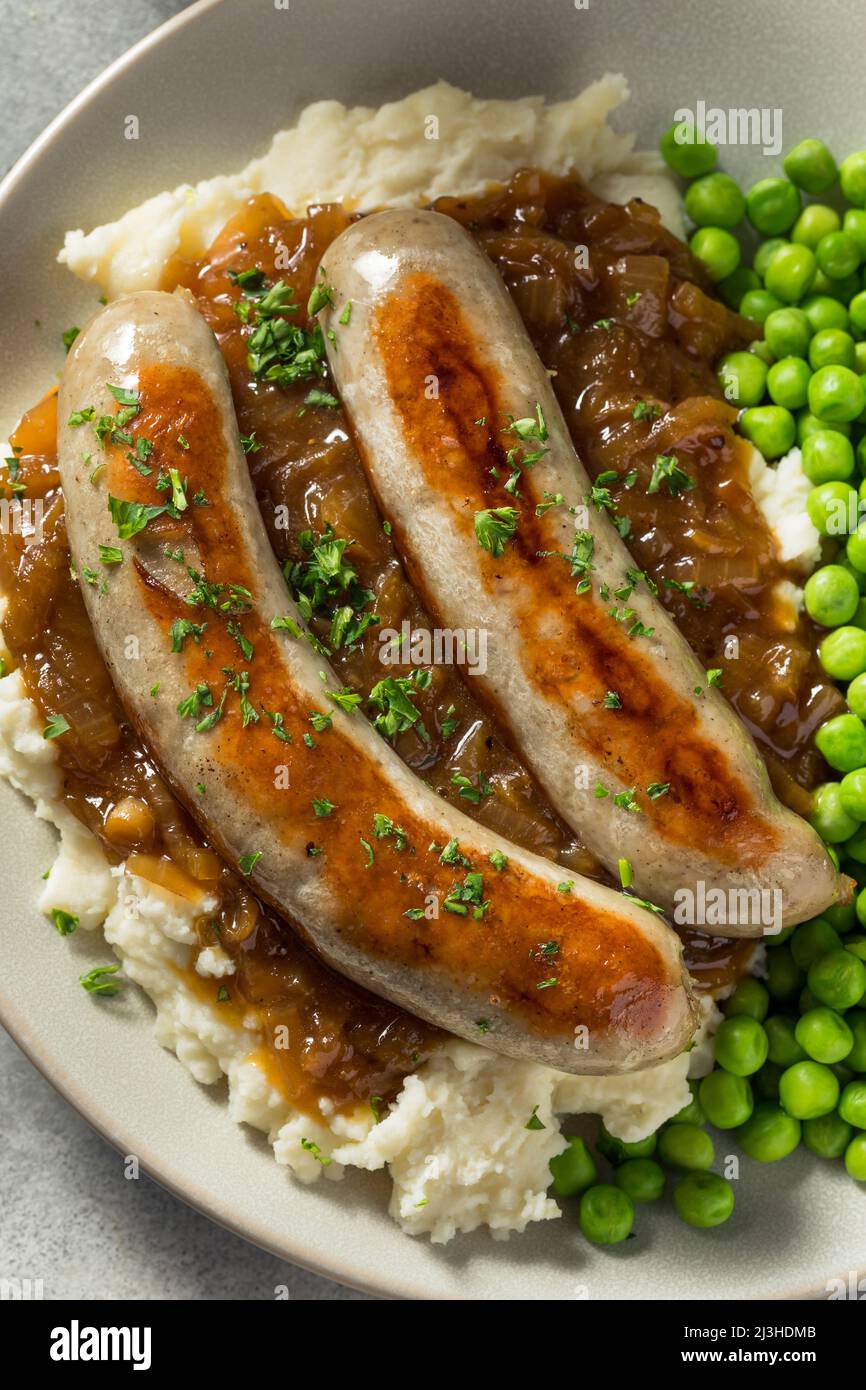 Hausgemachte britische Bangers und Maische mit Zwiebelsoße Stockfoto