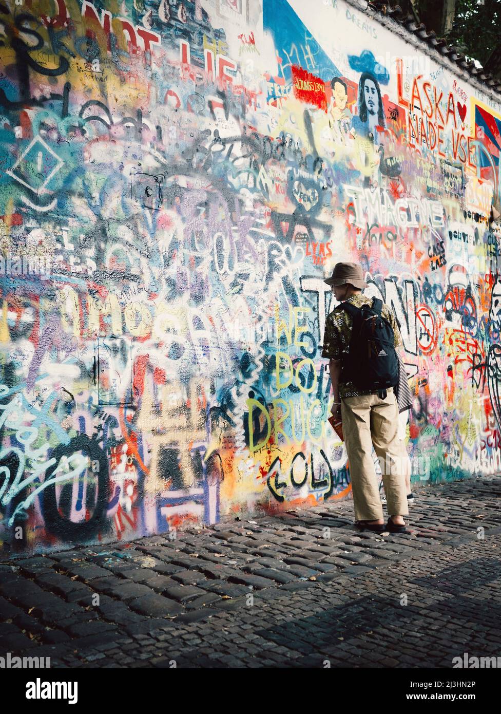 Mann, der vor einer Graffiti-Wand in Prag steht (John Lennon Wall) Stockfoto