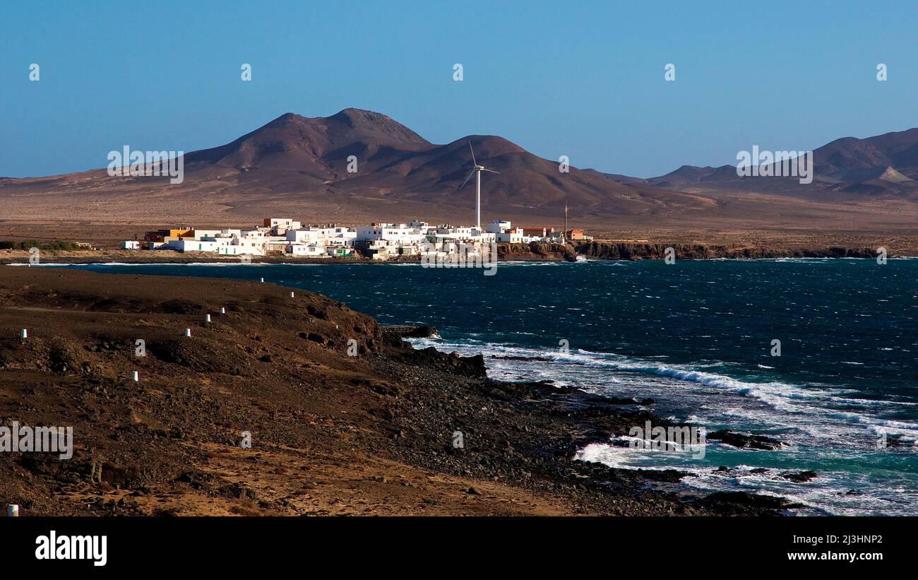 Spanien, Kanarische Inseln, Fuerteventura, Südwestspitze, karge Landschaft, Punta de Jandia, kleine Siedlung in karger Landschaft, Windgenerator, Brandung Stockfoto