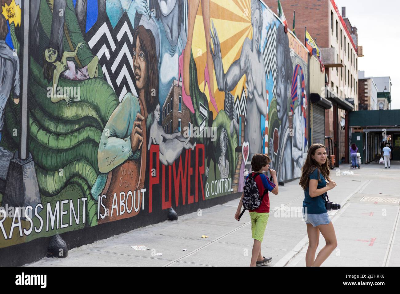 Myrtle AV/Broadway, New York City, NY, USA, 14 Jahre altes kaukasisches Teenager-Mädchen und 12 Jahre altes kaukasisches Teenager-Mädchen - beide mit braunen Haaren und sommerlichem Styling neben einem großen Graffiti in Brooklyn Stockfoto