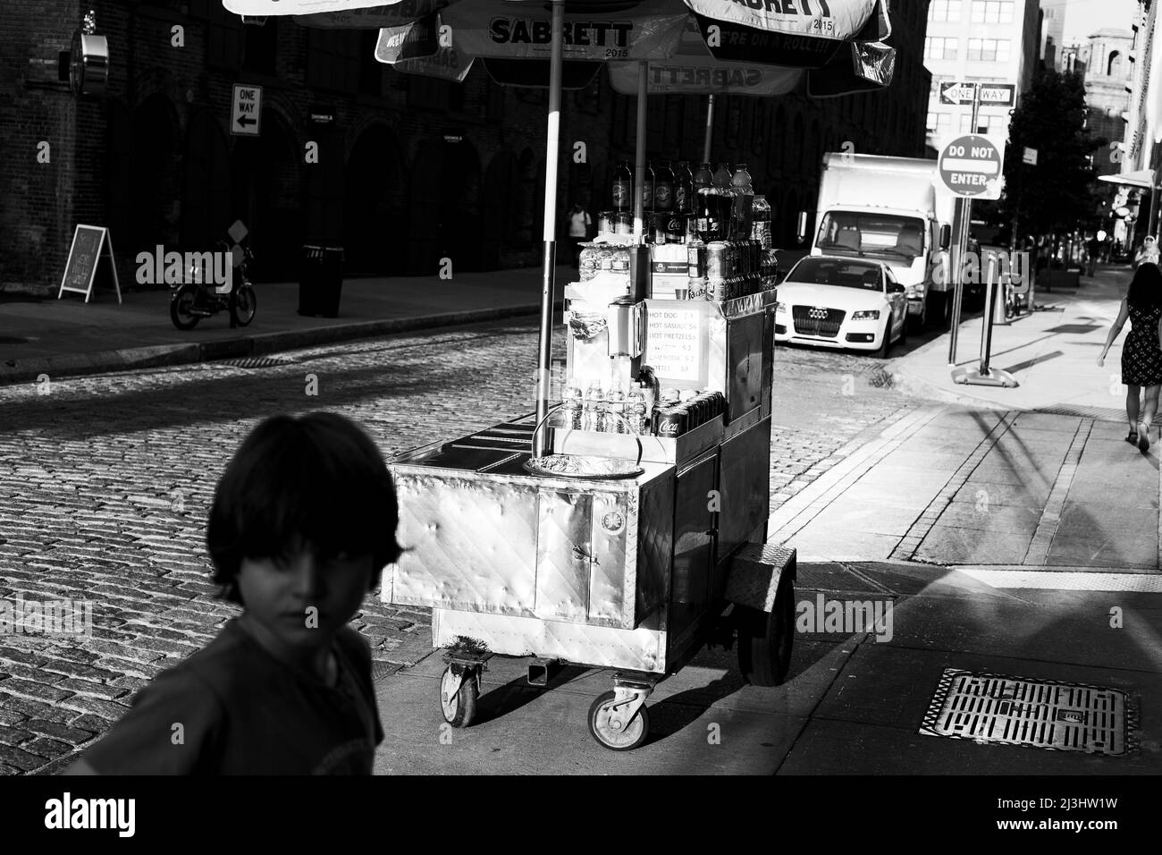 Brooklyn Heights, New York City, NY, USA, 12 Jahre alter kaukasischer Teenager-Junge - mit braunen Haaren und im Sommer-Outfit neben einem Straßenhändler in Brooklyn Stockfoto