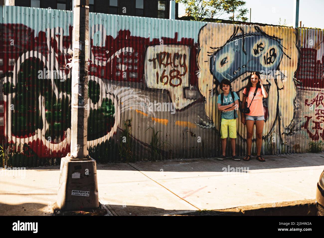 Myrtle AV, New York City, NY, USA, 14 Jahre altes kaukasisches Teenager-Mädchen und 12 Jahre altes kaukasisches Teenager-Mädchen – beide mit braunen Haaren und sommerlichem Styling vor einem Graffiti in Brooklyn Stockfoto