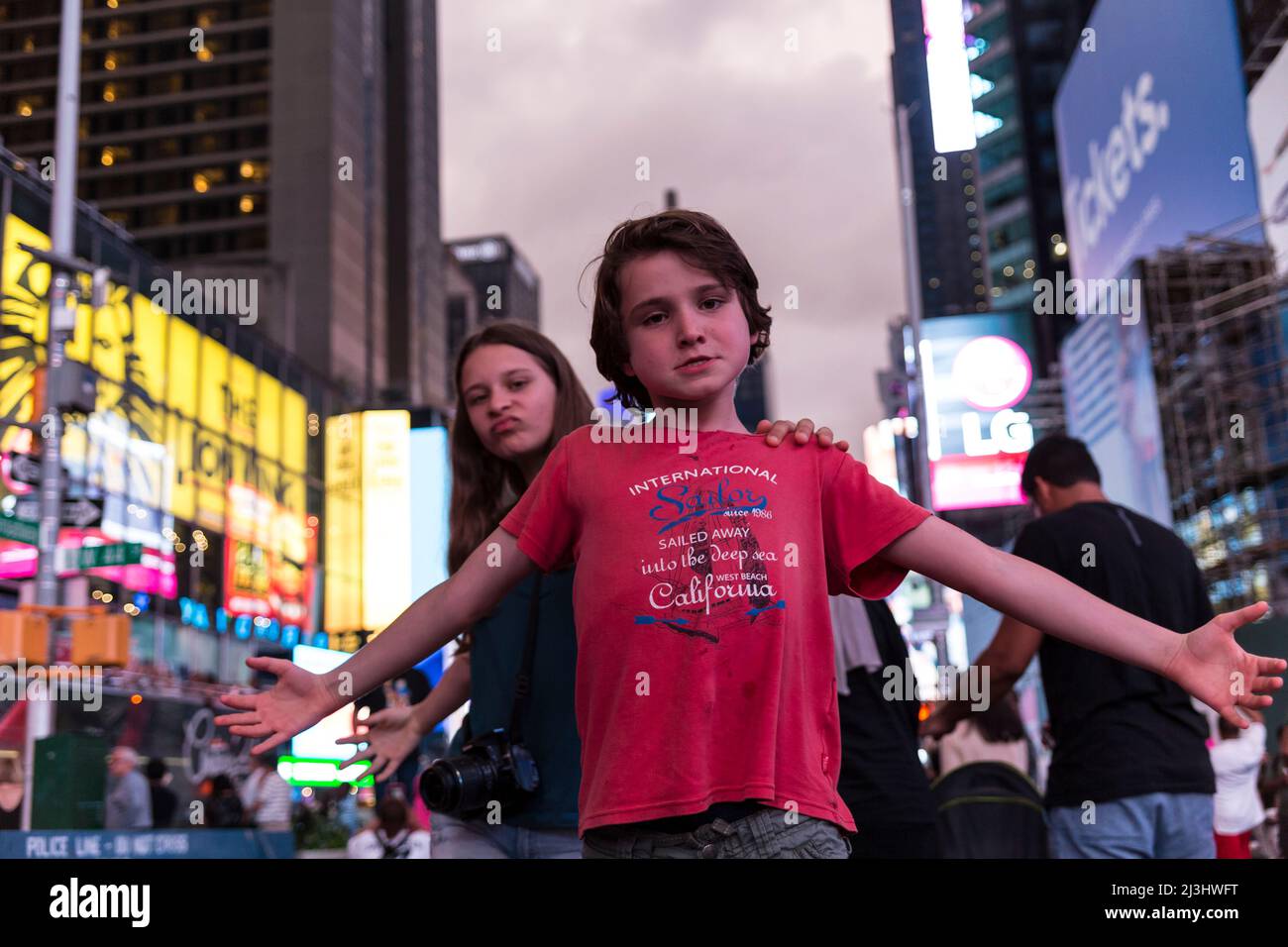 Theatre District, New York City, NY, USA, 14 Jahre altes kaukasisches Teenager-Mädchen und 12 Jahre altes kaukasisches Teenager-Mädchen – beide mit braunen Haaren und sommerlichem Styling posieren auf dem Times Square Stockfoto
