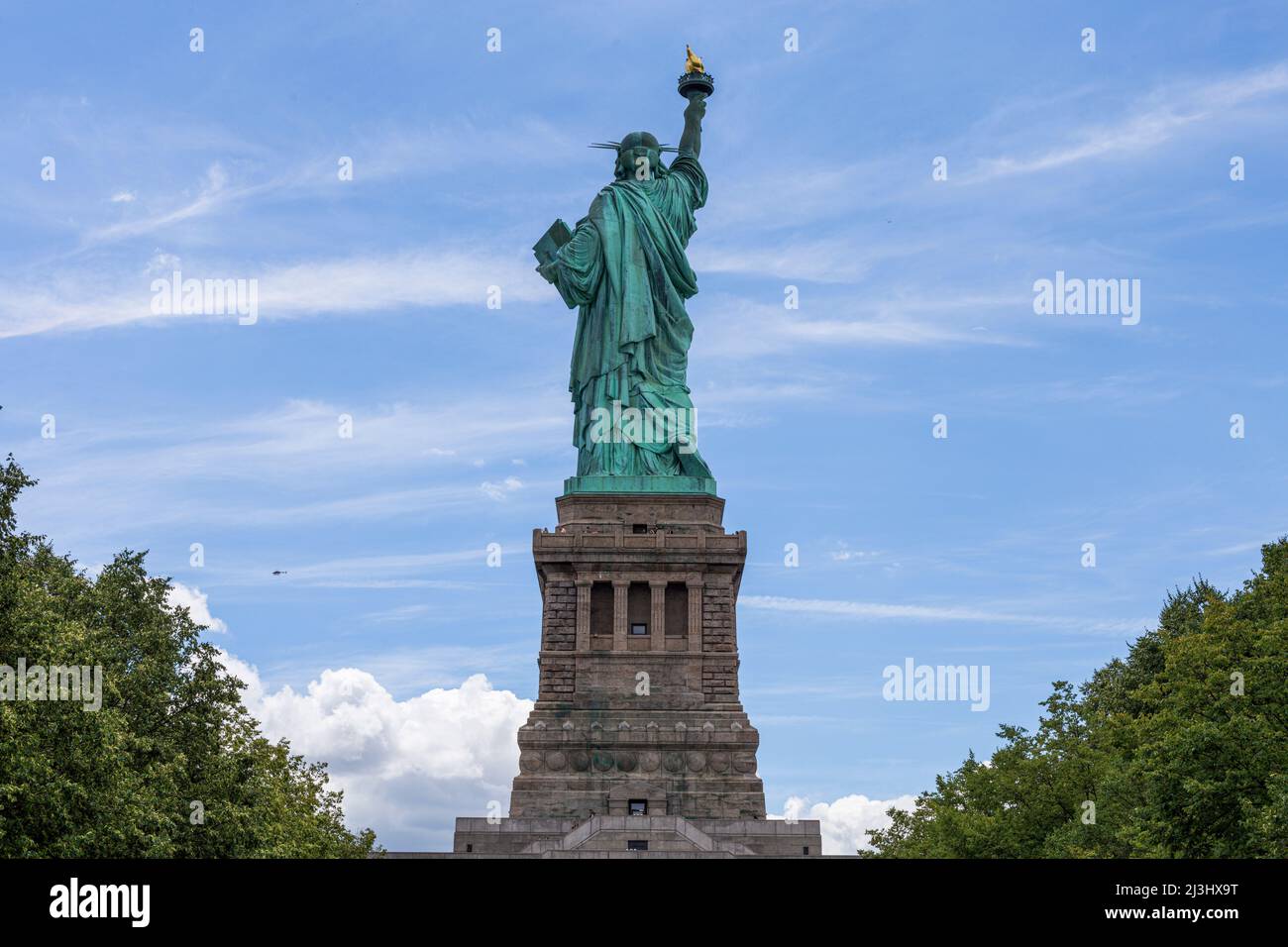Liberty Island, NYC, NEW York, USA, ein unerwarteter Blick auf die weltberühmte Freiheitsstatue in New York City. Gefangen vor einem dramatischen Himmel. Stockfoto