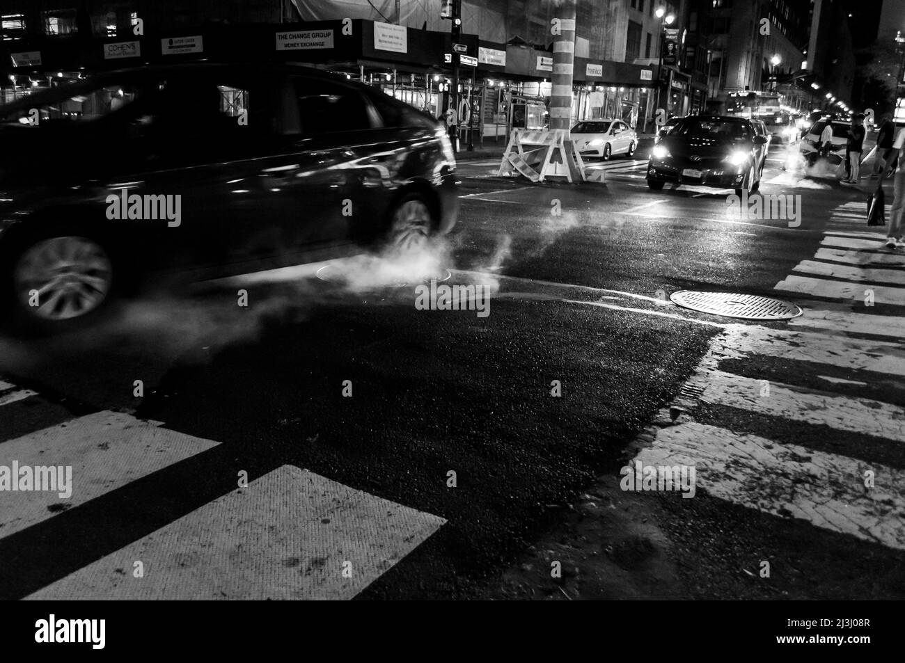GRAND CENTRAL Terminal New York City, NY, USA, Manhattan Straßenszene mit Autos, die durch Dampf fahren, der von der Schachtabdeckung kommt Stockfoto GRAND CENTRAL Terminal New York City, NY, USA, Manhattan Straßenszene mit Autos, die durch Dampf fahren, der von der Schachtabdeckung kommt Stockfoto