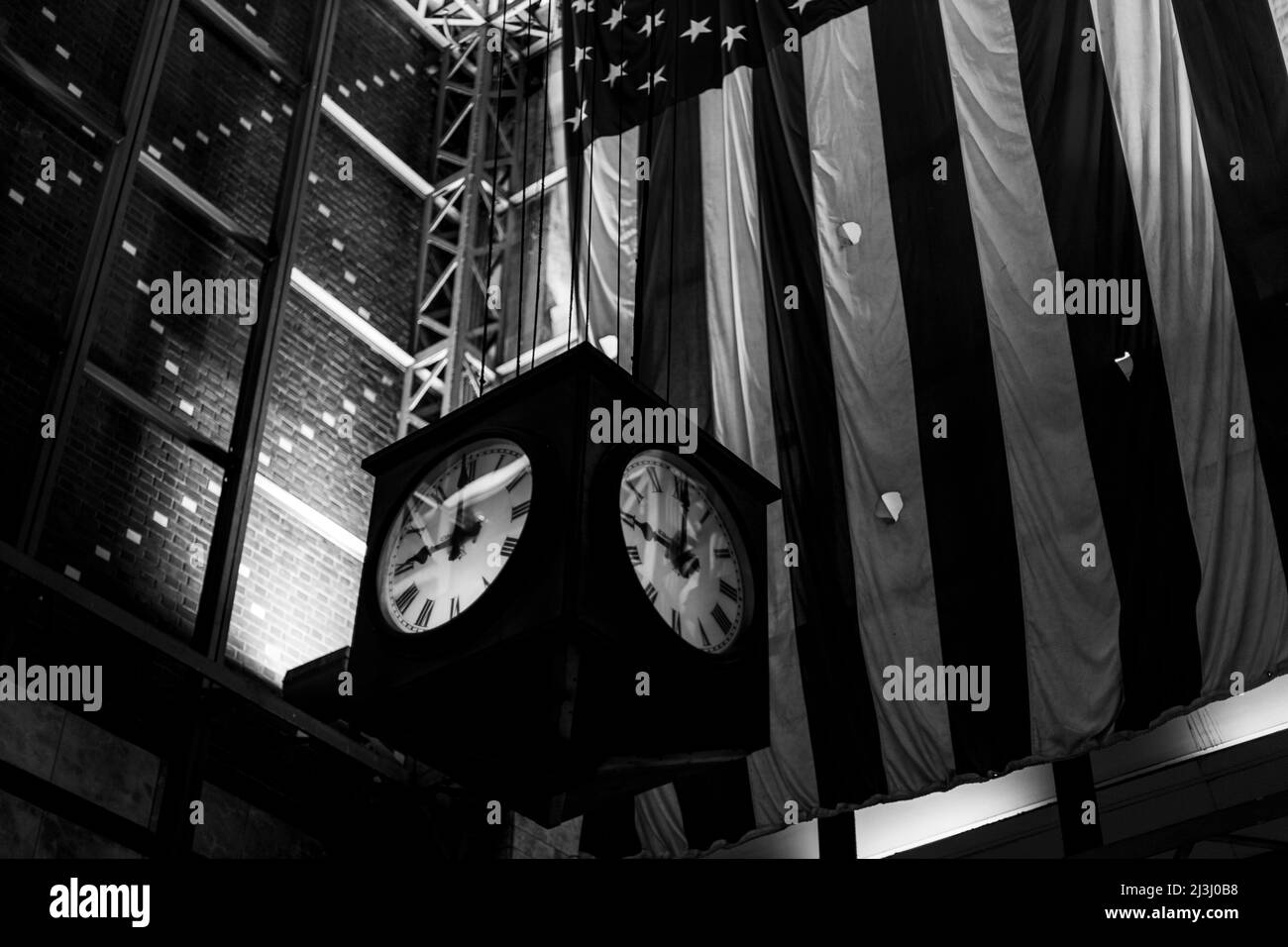 W 34 ST/7 AV, New York City, NY, USA, die amerikanische Flagge hinter einer Uhr Stockfoto