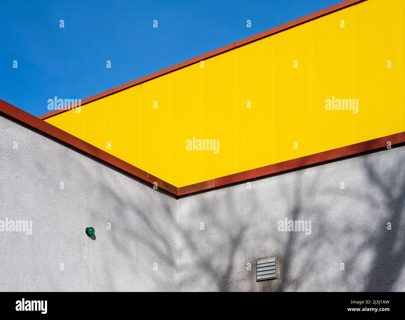 Gelbes Lagerhaus, blauer Himmel, Schatten, Stockfoto