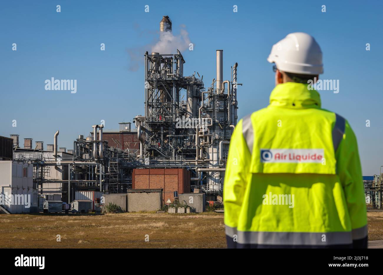 Oberhausen, Nordrhein-Westfalen, Deutschland - Air Liquide, Wasserstoffproduktion im Chemiepark OQ Chemicals. Mitarbeiter von Air Liquid mit Firmenlogo auf gelbem Mantel vor der POX-Anlage (Partial Oxidation) zur konventionellen Produktion von Wasserstoff und Synthesegas. Stockfoto