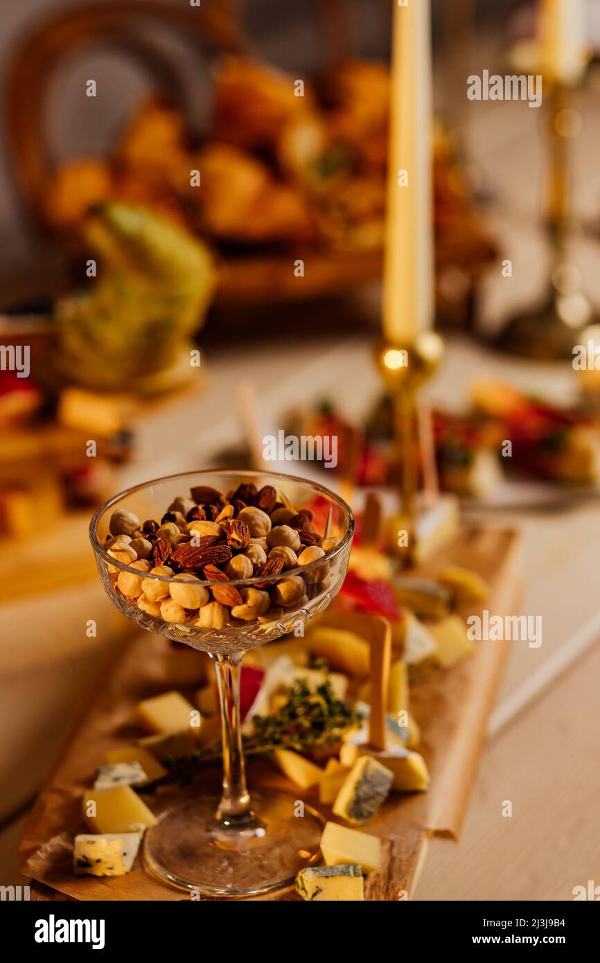 Sortiment von Nüssen in Schalen. Cashewkerne, Haselnüsse, Walnüsse, Pistazien, Pekannüsse, Pinienkerne, Erdnüsse, Macadamia, Mandeln, paranüsse. Lebensmittelmix auf Holz Stockfoto