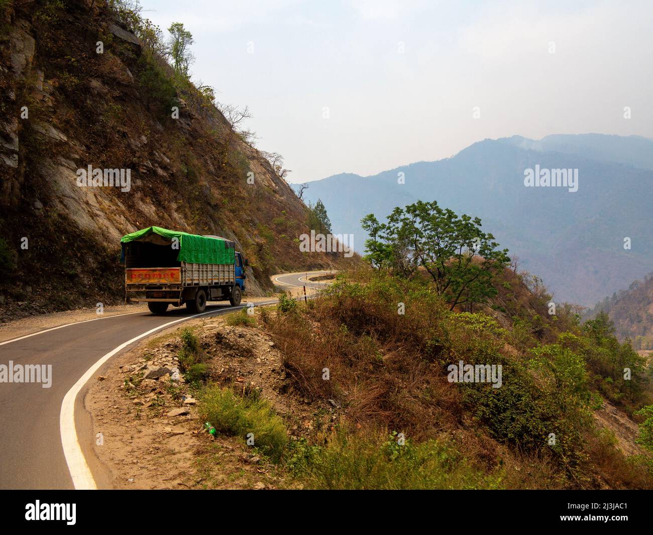 Indian Truck auf der schmalen Straße durch tiefe Täler auf Kumaon Hills, Uttarakhand, Indien Stockfoto