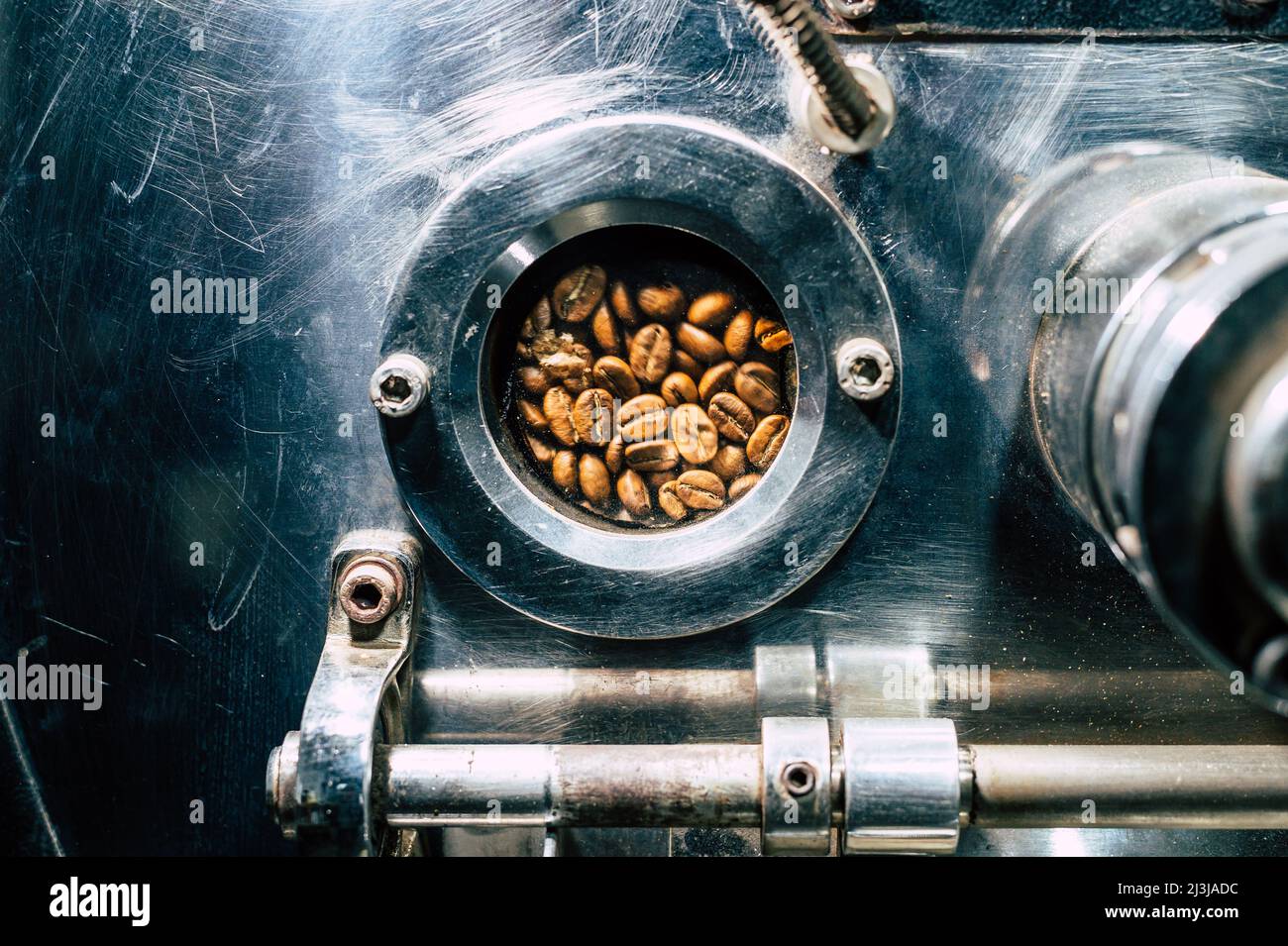 Kaffeebohnen rotieren in einer Kaffeebohnen-Röstermaschine Stockfoto