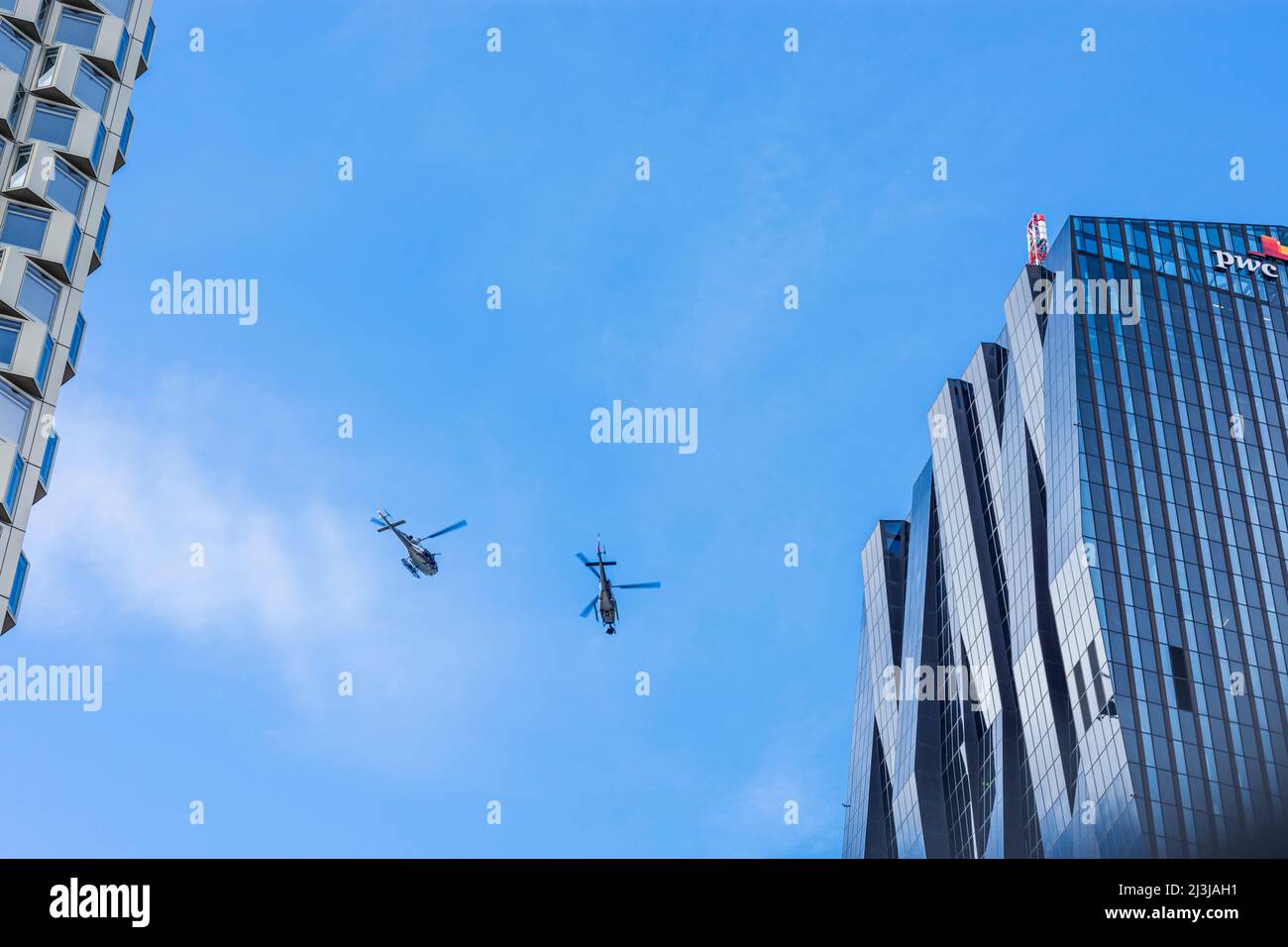 Wien, 2 Helikopter für Dreharbeiten zu Netflix Film 'Tyler Rake ñ Extraction' mit Schauspieler Chris Hemsworth vor dem Wolkenkratzer DC Tower 1, Hubschrauber mit Polizeiaufschrift ist privat und hat eine Kamera im Bezirk 22 davor montiert. Donaustadt, Österreich Stockfoto