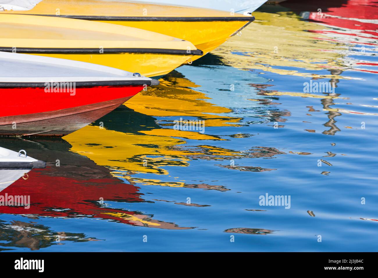 Bunte Boote liegen nebeneinander in einem der Wasserkanäle von Venedig, spiegeln sich im Wasser, Italien, Venetien Stockfoto