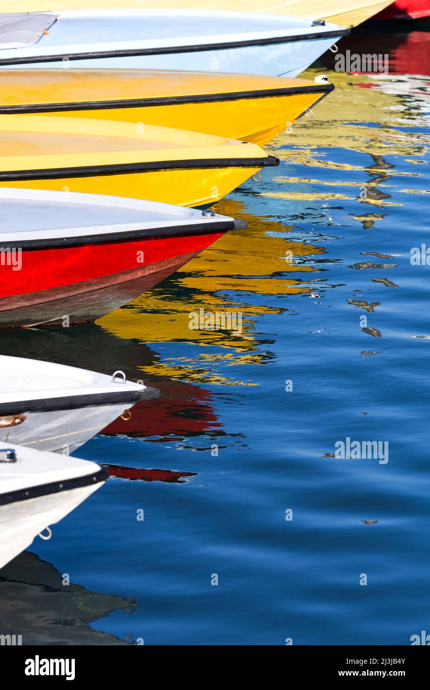 Bunte Boote liegen nebeneinander in einem der Wasserkanäle von Venedig, spiegeln sich im Wasser, Italien, Venetien Stockfoto