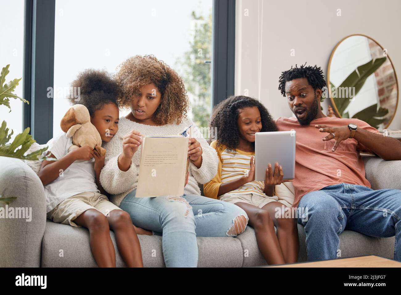 Das Lernen kann auf zwei verschiedene Arten erfolgen. Aufnahme einer jungen Familie, die zu Hause Zeit mit einem digitalen Tablet verbringt. Stockfoto