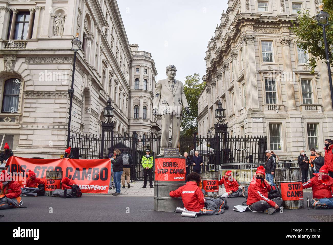 London, Großbritannien. 11.. Oktober 2021. Eine mit gefälschtem Öl beschmierte Statue von Boris Johnson, die von den Aktivisten errichtet wurde. Greenpeace-Aktivisten sperrten sich außerhalb der Downing Street in Fässer, um gegen das Ölfeld Cambo zu protestieren. Stockfoto