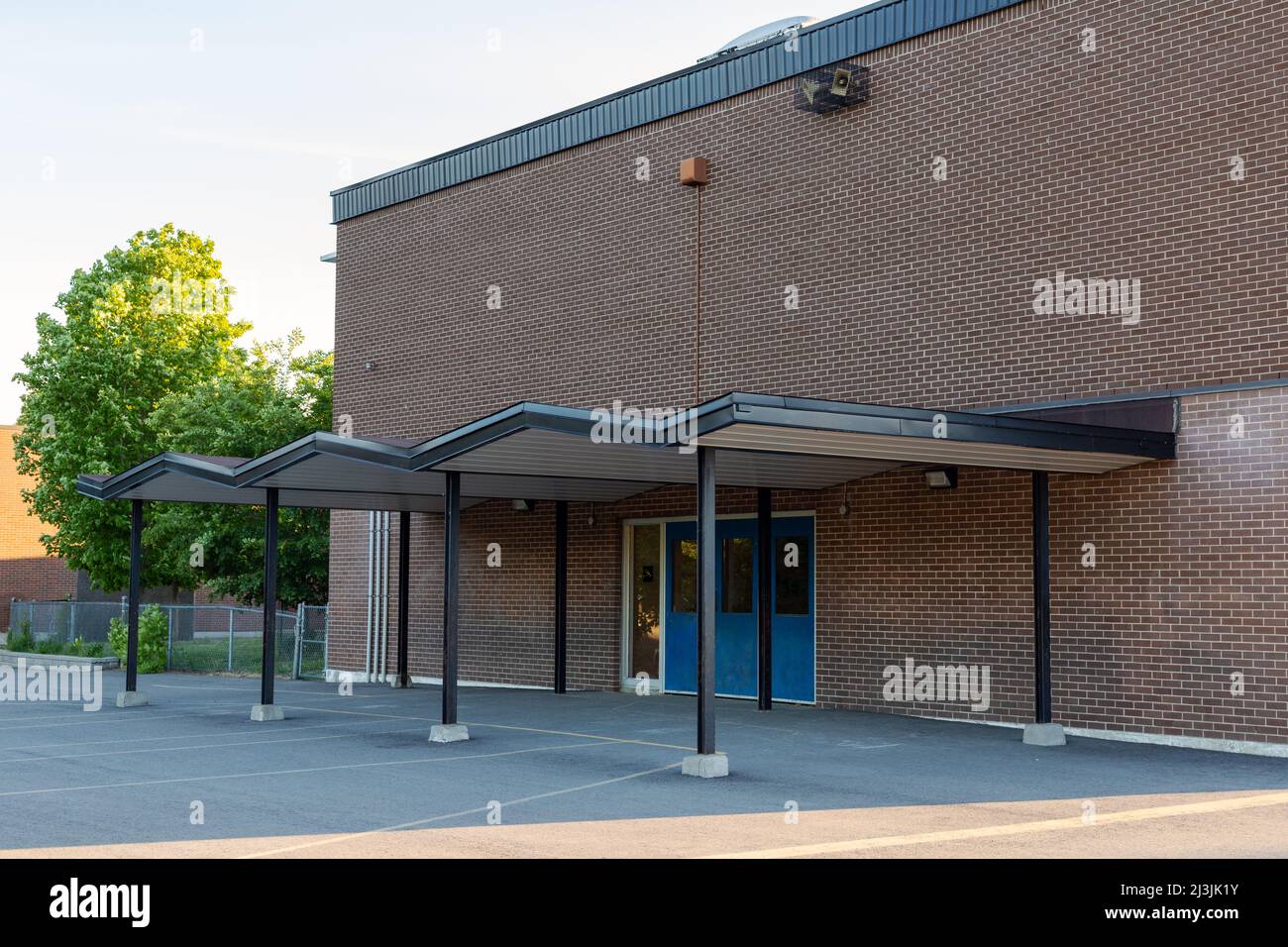 Die Fassade des Schulgebäudes und des Schulhofes am Abend Stockfoto