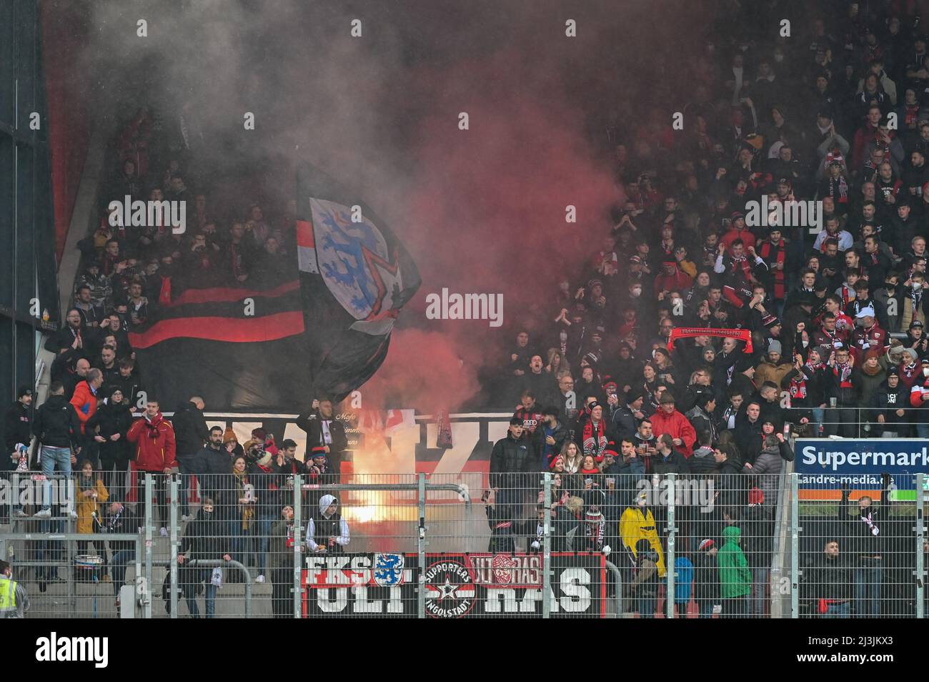 Regensburg, Deutschland. 08. April 2022. Fußball: 2. Bundesliga, Jahn Regensburg - FC Ingolstadt 04, Matchday 29, Jahnstadion Regensburg. Ingolstädter Fans zünden vor dem Spiel Bengalfeuer an. Quelle: Armin Weigel/dpa - WICHTIGER HINWEIS: Gemäß den Anforderungen der DFL Deutsche Fußball Liga und des DFB Deutscher Fußball-Bund ist es untersagt, im Stadion und/oder vom Spiel aufgenommene Fotos in Form von Sequenzbildern und/oder videoähnlichen Fotoserien zu verwenden oder zu verwenden./dpa/Alamy Live News Stockfoto