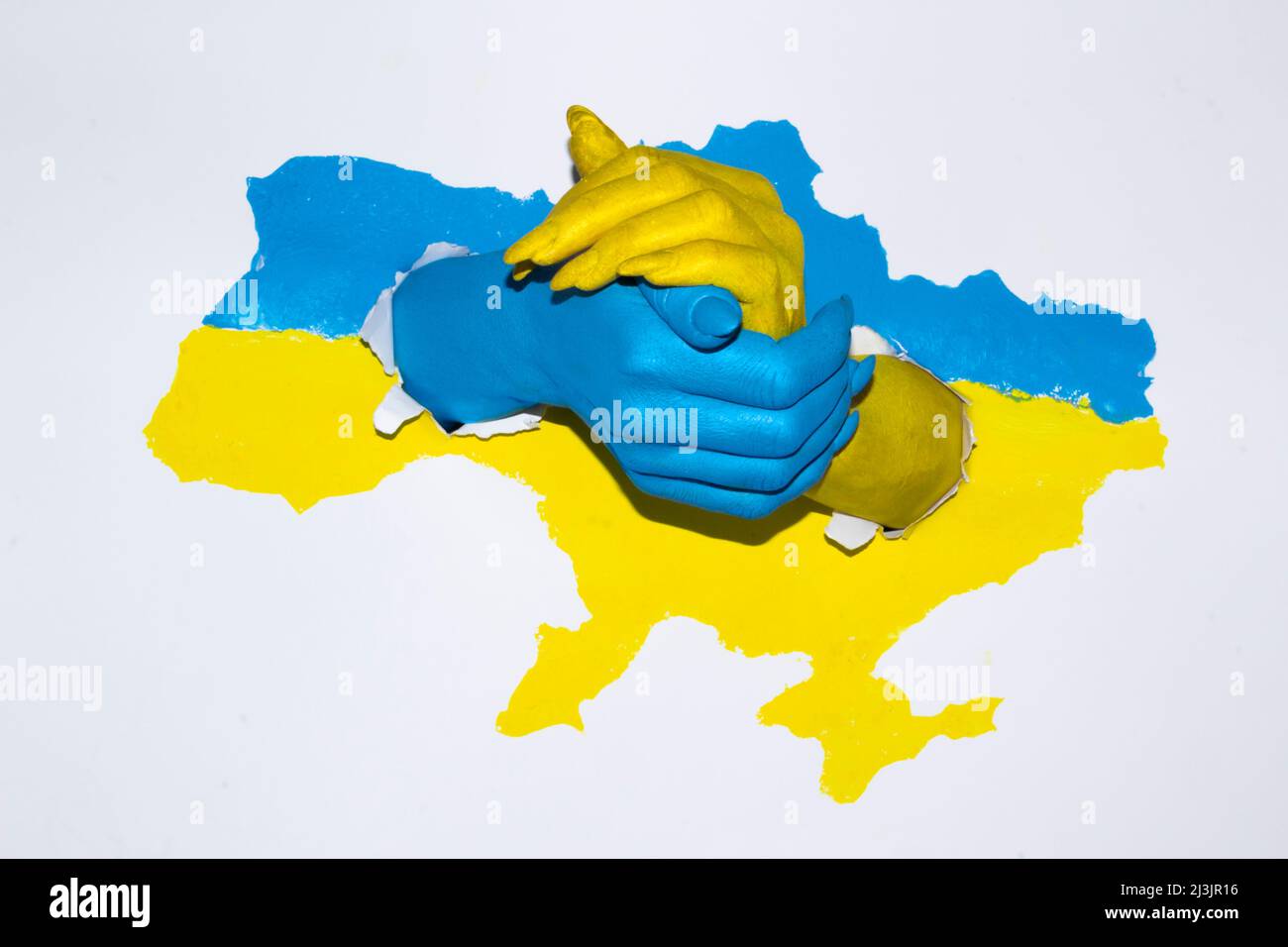 Zeichnung Karte der Ukraine in blau-gelber Farbe mit weiblichen Händen, die sich halten. Frau Hände in Farbe mit Flagge der Ukraine gemalt. Stockfoto
