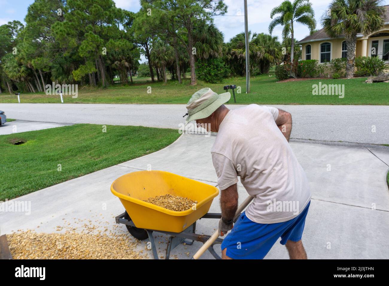 Der Mann beugt sich, um in Florida Steine zu schaufeln Stockfoto