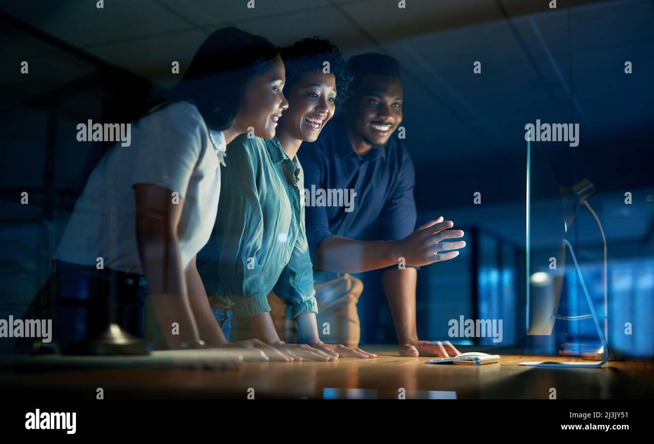 Wir bekommen, was wir uns Zeit geben. Aufnahme einer Gruppe junger Geschäftsleute, die während einer späten Nacht auf der Arbeit einen Computer zusammen benutzen. Stockfoto