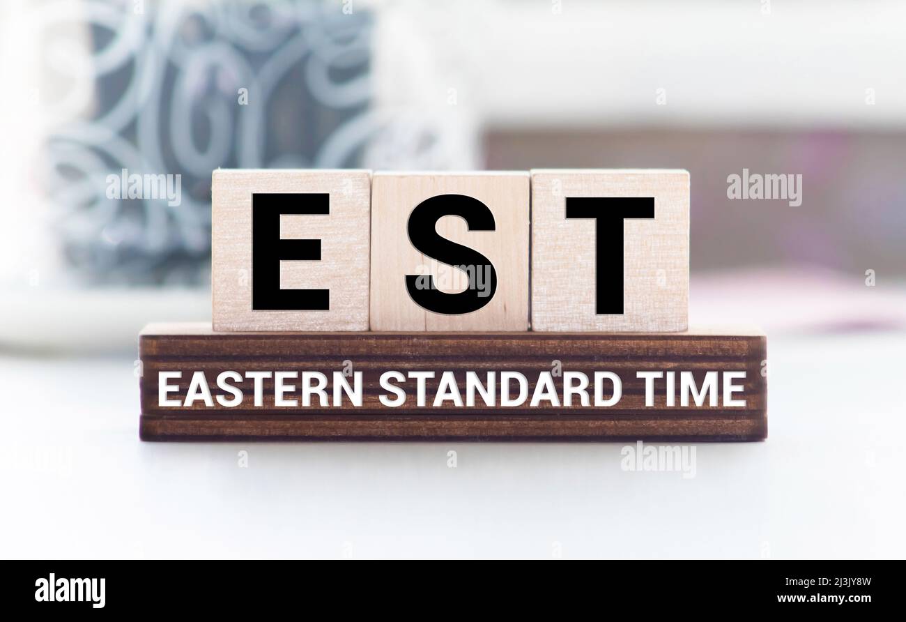 Alphabet Buchstabe in Wort EST Abkürzung für etablierte, geschätzte, östliche Zeitzone, ausgedrückte Sequenzkennzeichnung auf Holzhintergrund Stockfoto
