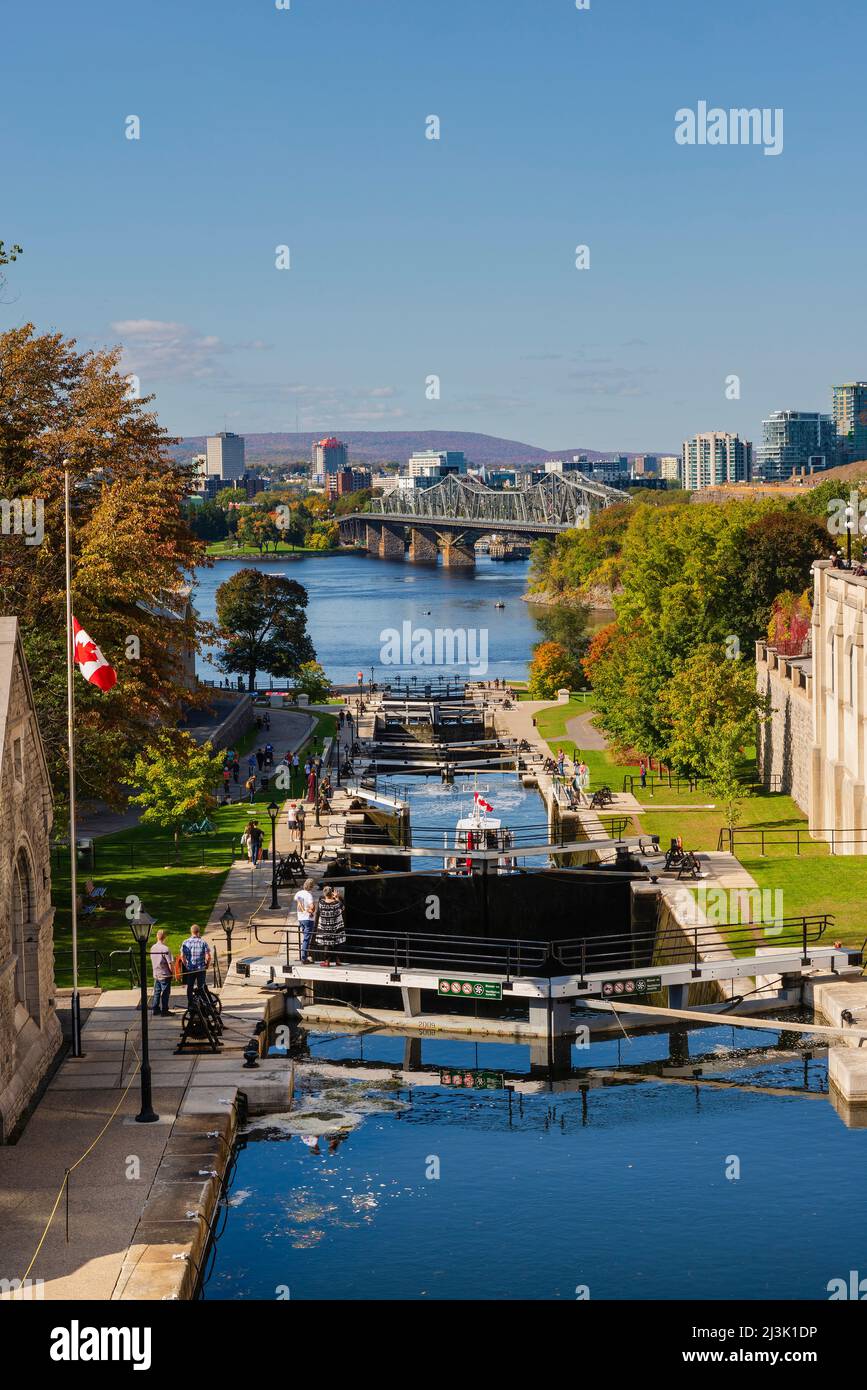 Gebäude und Parkbereiche entlang des Rideau Canal mit einer Reihe von Bootsschleusen; Ottawa, Ontario, Kanada Stockfoto
