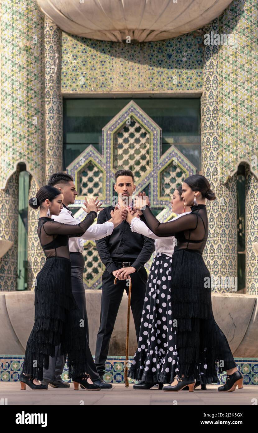 Vertikales Foto eines Flamenco-Lehrers mit seinen Schülern vor einem Hintergrund mit arabischen Dekorationen Stockfoto