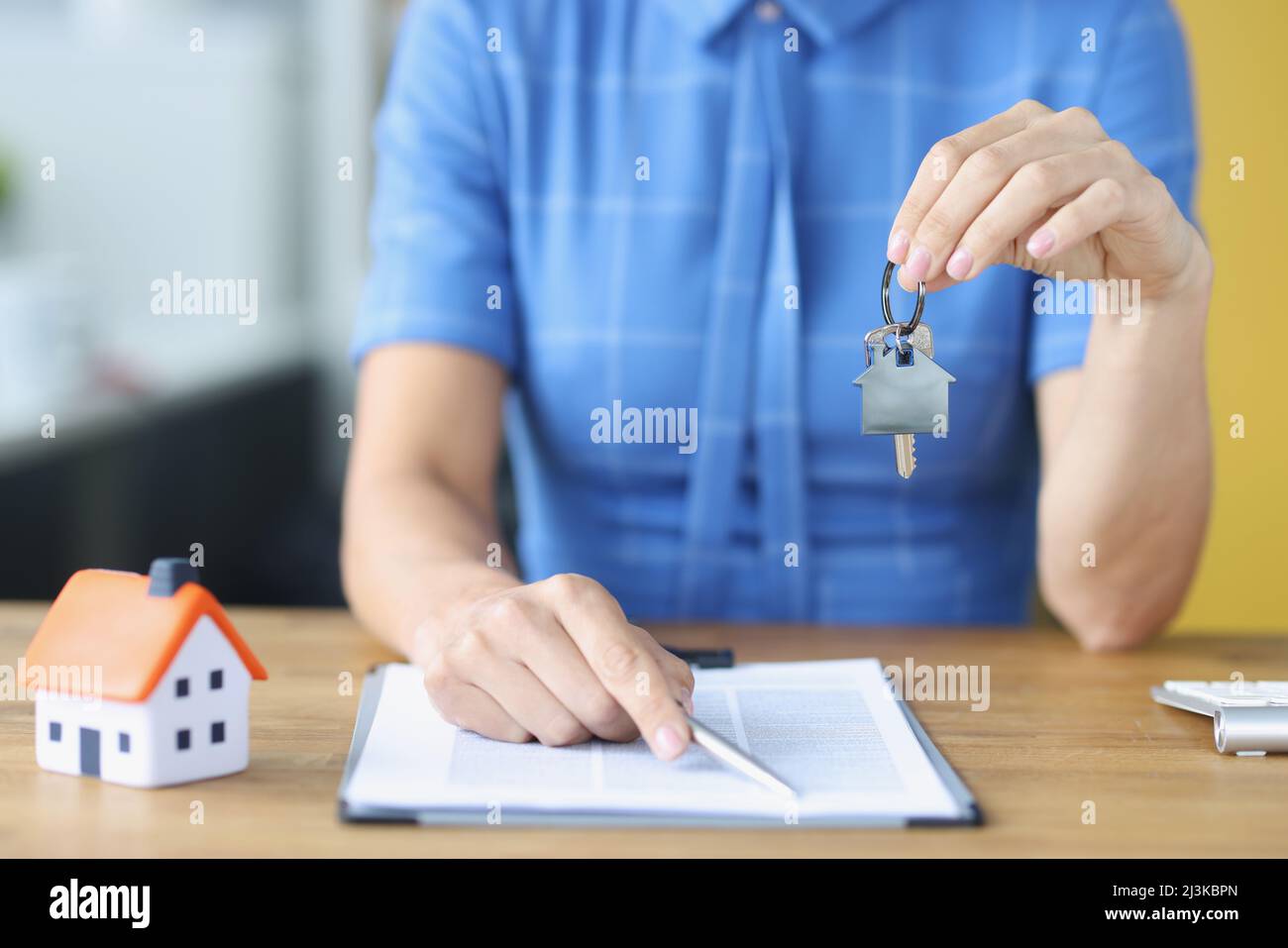 Versicherungsvertreter hält Hausschlüssel und Vertrag für den Kauf von Haus Stockfoto