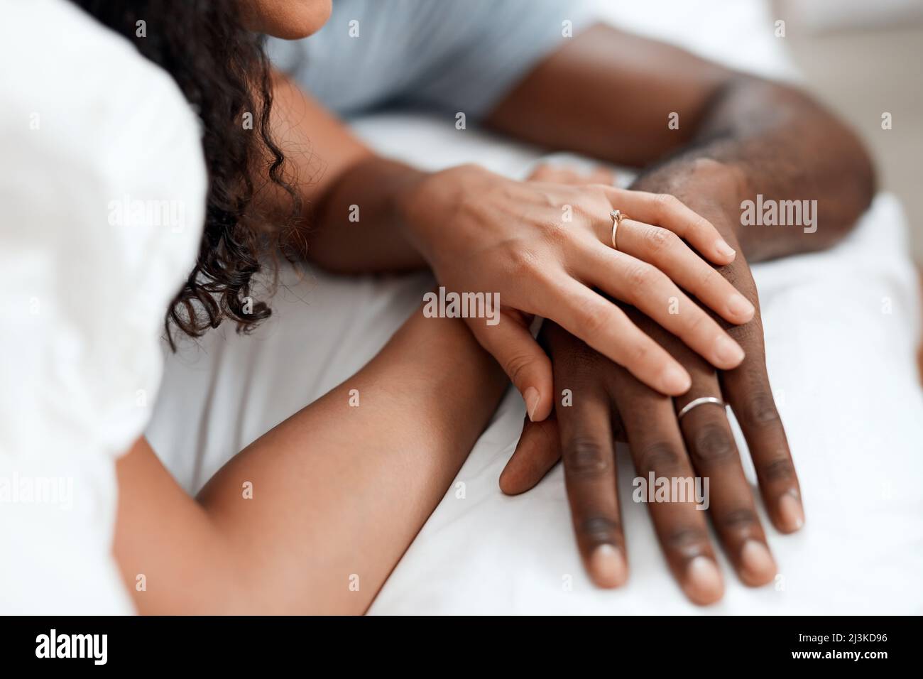 Gemeinsam in diesem und im nächsten Leben. Nahaufnahme eines unverkennbaren Paares Hände halten einander, während sie im Bett zu Hause am Morgen schlafen. Stockfoto