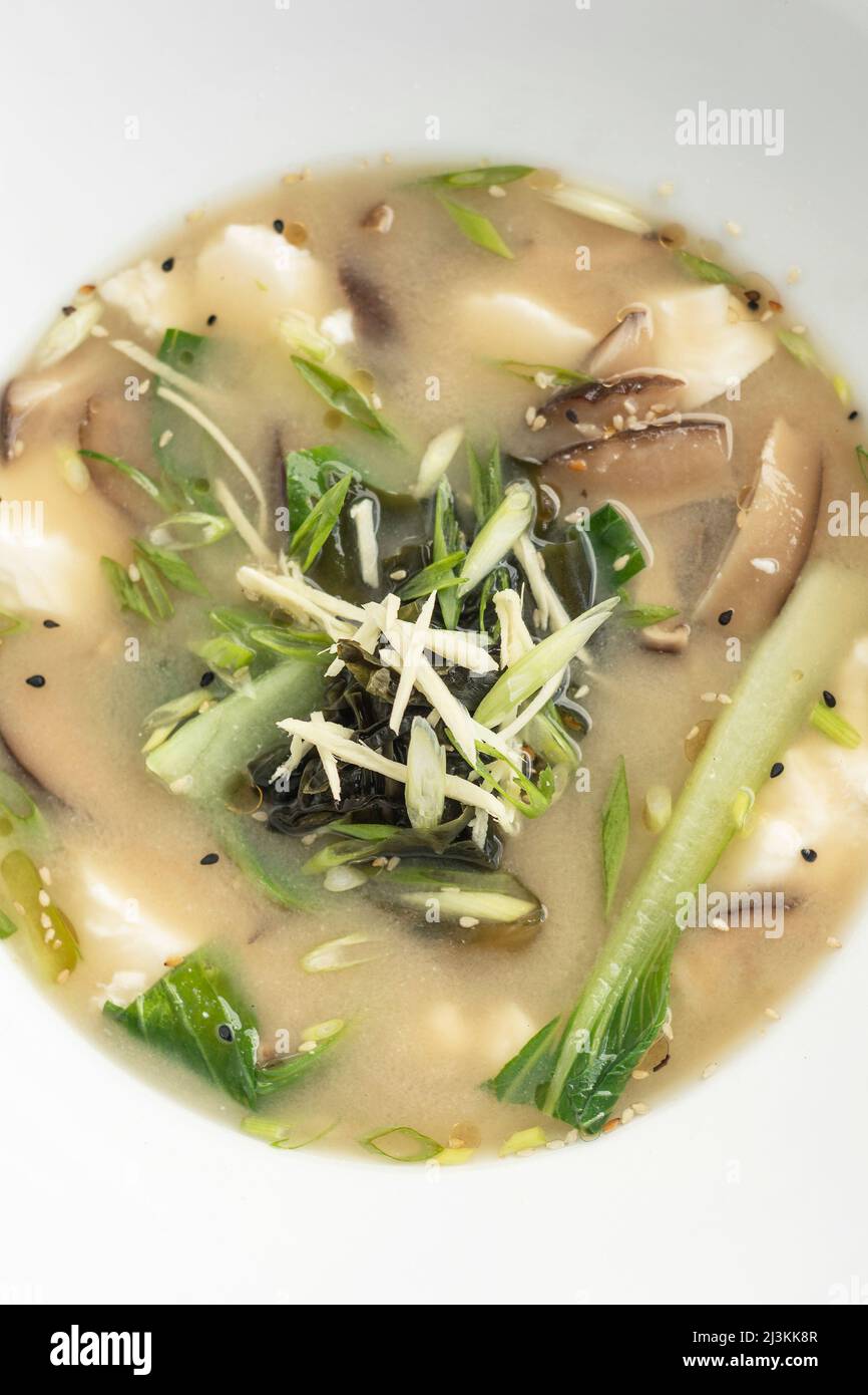Traditionelle japanische Miso-Suppe mit Tofu und gemischtem Gemüse auf weißem Hintergrund Stockfoto