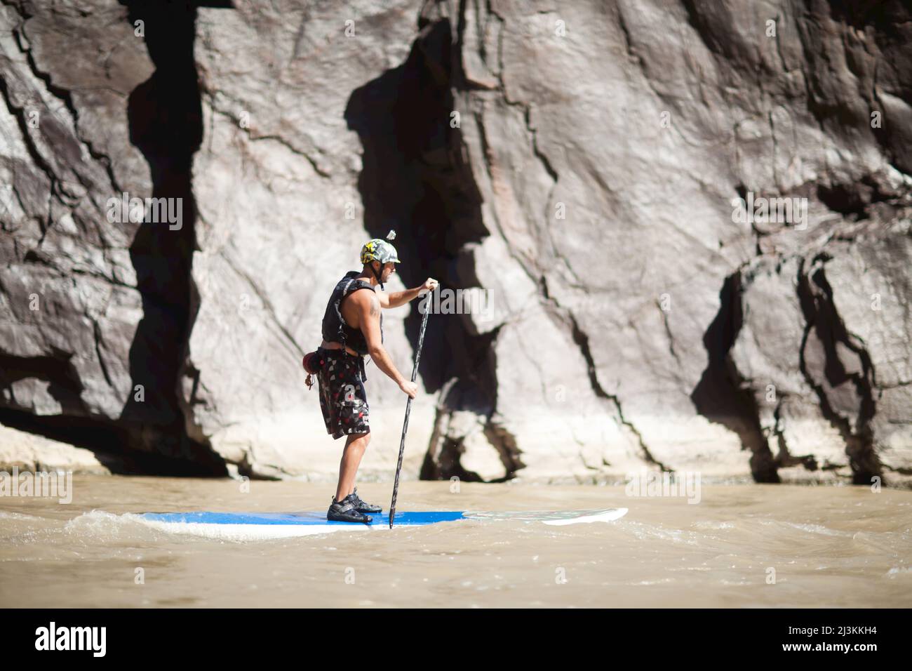 Ein Mann surft auf seinem Stand Up Paddleboard auf dem Colorado River in einem Abschnitt namens Westwater. Stockfoto