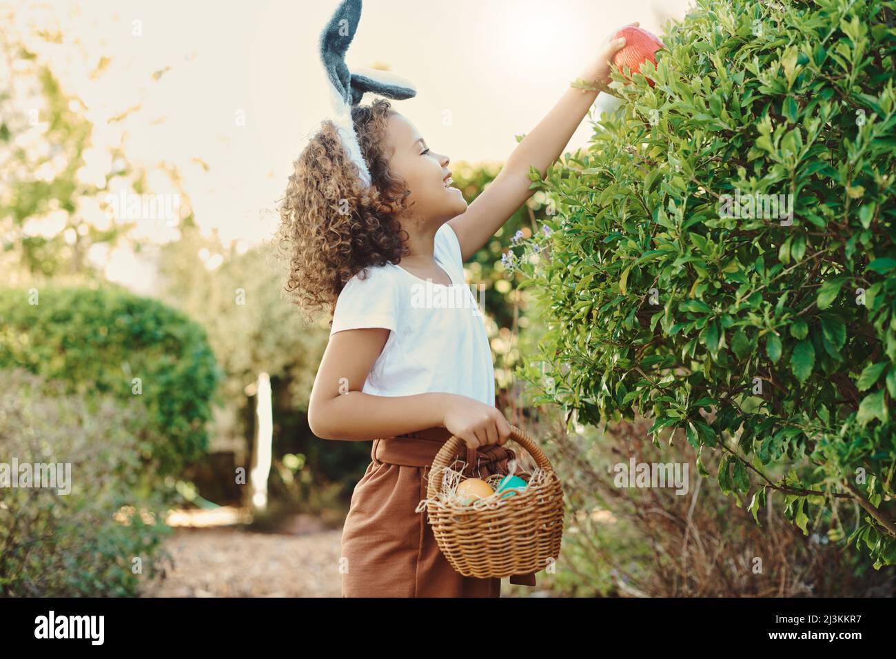 Diese Verstecke sind so einfach. Aufnahme eines kleinen Mädchens, das auf Schatzsuche nach ostereiern geht. Stockfoto